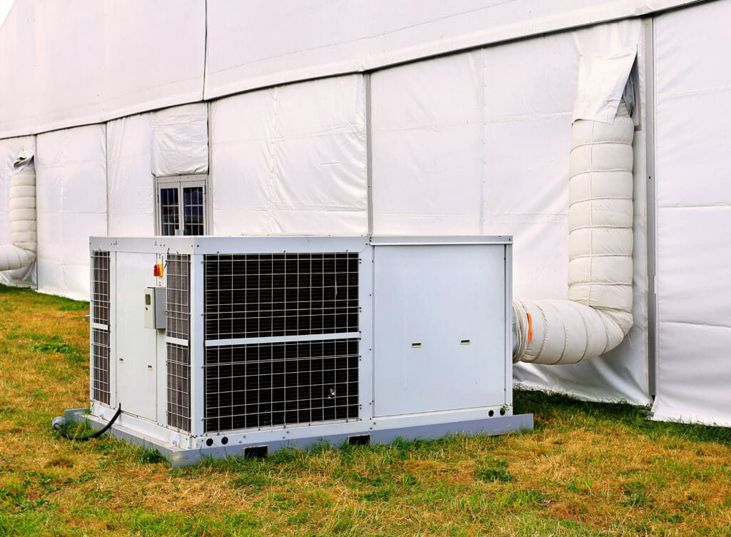 Weiße Zeltheizung vor Zelt mit Warmluftschlauch nach innen